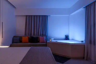 a room with a tub and a bed and a couch at VENTUS Luxury Suites in Khóra Sfakíon