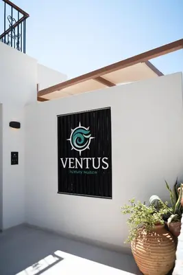 a sign on the side of a wall with a vittilus logo at VENTUS Luxury Suites in Khóra Sfakíon