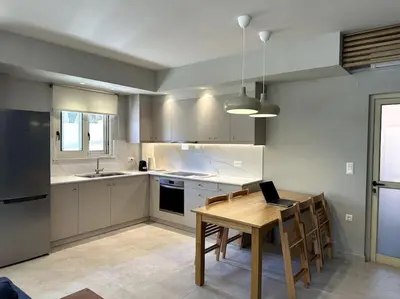 a kitchen with a table with a laptop on it at Sunny flat among olive trees, next to the beach in Módhion