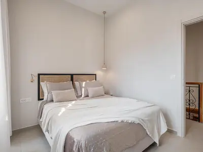 a bedroom with a large bed with white sheets and pillows at Casa Benedetta in Chania Town