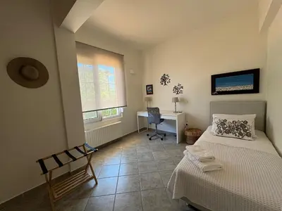 a bedroom with a bed and a desk and a window at Primavera Retreat in Chania Town