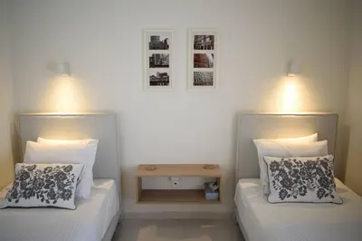 a bedroom with two beds and a nightstand between them at Verano Retreat in Chania Town