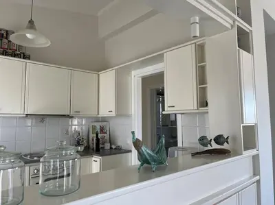 a white kitchen with white cabinets and a counter top at Verano Retreat in Chania Town