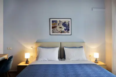 a bedroom with a blue bed with two lamps at Cosy apartment near the beach in Chania Town