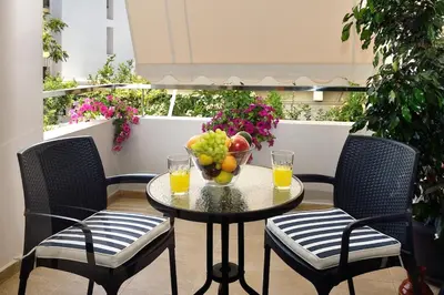 a table with a bowl of fruit and two glasses of orange juice at Cosy apartment near the beach in Chania Town