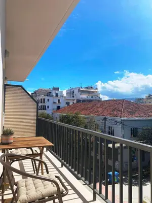 a balcony with a wooden table and chairs on it at Kidonias apartment in Chania Town