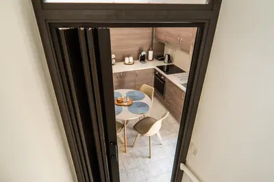 a view of a kitchen with a table and chairs at Be Crete - Solis maisonette in Chania Town