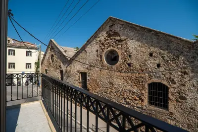 an old brick building with a black fence at Be Crete - Solis maisonette in Chania Town