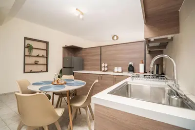 a kitchen with a sink and a table with chairs at Be Crete - Solis maisonette in Chania Town