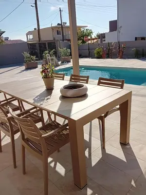 a wooden dining table and chairs with a pool at EVAMAR, Premium Living in Chania Town