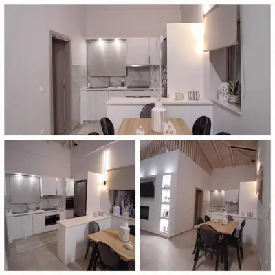 a kitchen and dining room with white cabinets and a table at EVAMAR, Premium Living in Chania Town