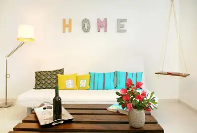 a living room with a couch and a table with a wine bottle at Stylish house 2 min from the beach! VERY FAST WF in Daratso