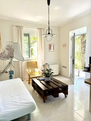 a bedroom with a bed and a table in it at Stylish house 2 min from the beach! VERY FAST WF in Daratso