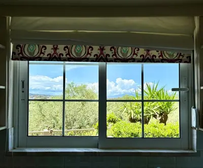a window in a room with a view of a field at Stylish house 2 min from the beach! VERY FAST WF in Daratso