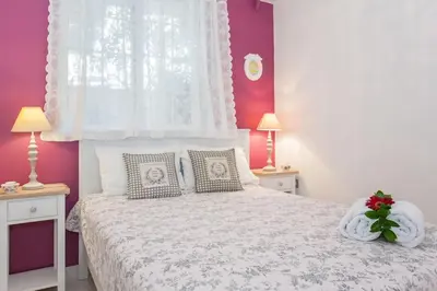a bedroom with a white bed with purple walls at Stylish house 2 min from the beach! VERY FAST WF in Daratso