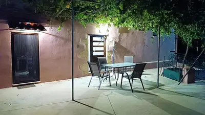 a patio with a table and chairs in front of a building at Xanthippi's in Pemónia