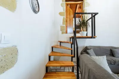 a spiral staircase in a living room with a couch at Xanthippi's in Pemónia