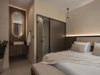 a bedroom with a large bed and a mirror at Copal Simple Staying in Chania Town