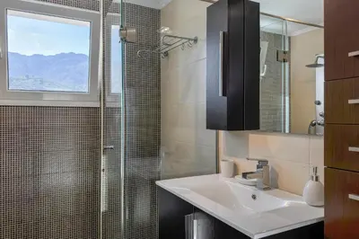 a bathroom with a sink and a glass shower at Villa Adam in Chania Town