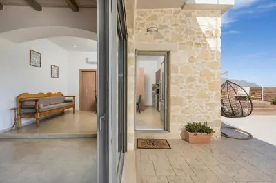 an open door to a patio with a couch at Villa Eleftheria in Áyios Yeóryios