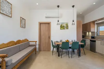 a living room with a couch and a table and chairs at Villa Eleftheria in Áyios Yeóryios