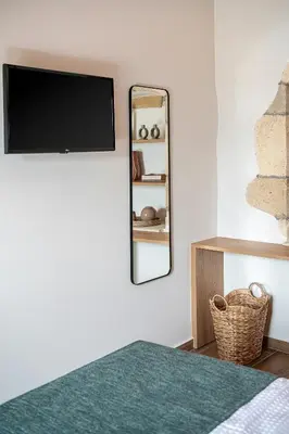 a bedroom with a tv and a mirror on the wall at Casa Nougia in Chania Town