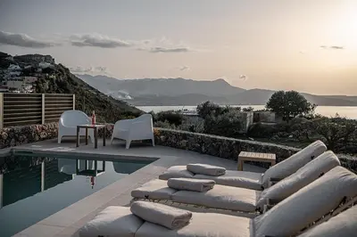 a pool with chaise lounges and a table and chairs at Casa Nougia in Chania Town