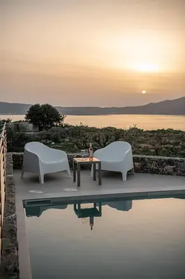 two chairs and a table sitting next to a pool at Casa Nougia in Chania Town