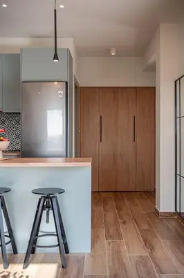 a kitchen with wooden cabinets and a counter with stools at Casa Nougia in Chania Town