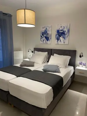 a bedroom with two beds and a chandelier at Stefania's House in Chania Town