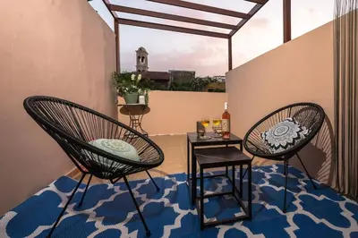 a patio with two chairs and a table on a balcony at Splatzia old town maizonette in Chania Town