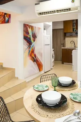 a kitchen with a table with chairs and a painting at Splatzia old town maizonette in Chania Town