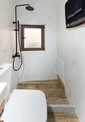 a bathroom with a shower and a toilet and a window at Splatzia old town maizonette in Chania Town