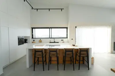 a kitchen with a island with bar stools at Hygge Villa Evgenia in Kounoupidhianá