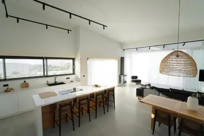 a kitchen and dining room with a table and chairs at Hygge Villa Evgenia in Kounoupidhianá