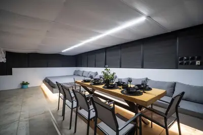 a dining room with a table and chairs and a bed at Montis villa sea view heated pool in Daratso