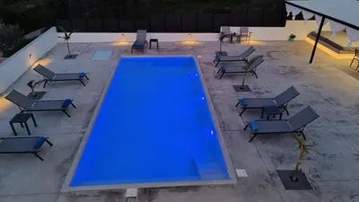 an overhead view of a pool with tables and chairs at Montis villa sea view heated pool in Daratso