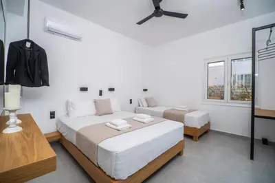 two beds in a room with white walls and windows at Montis villa sea view heated pool in Daratso