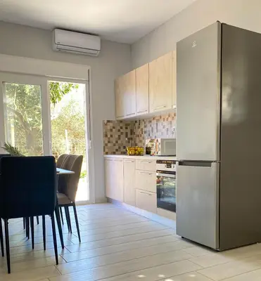 a kitchen with a refrigerator and a table and chairs at YVONNE's HOUSE in Chania Town