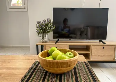 a bowl of green apples in a living room with a television at YVONNE's HOUSE in Chania Town