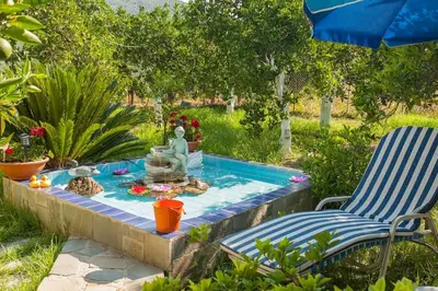 a garden with a table and two chairs and a fountain at Paradise Lost in Gerani Chanion