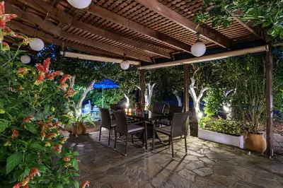 a patio with a table and chairs under a pergola at Paradise Lost in Gerani Chanion
