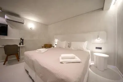 a bedroom with a white bed with towels on it at Amelia Luxury Suites Old Town in Chania Town