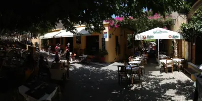 a street with tables and chairs and an umbrella at Xenon Apartments in Chania Town