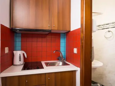 a small kitchen with a sink and red tiles at Xenon Apartments in Chania Town