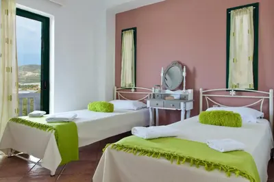 two beds in a room with a mirror at Villa Smaragdi - Private Sea View Villa in Falasarna
