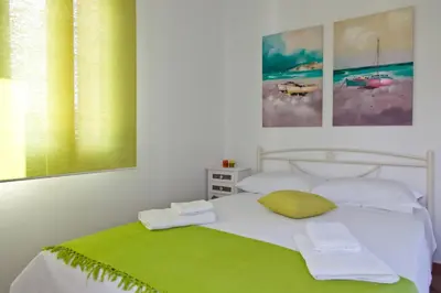 a bedroom with a white bed with a green blanket at Villa Smaragdi - Private Sea View Villa in Falasarna