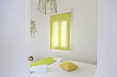 a room with a bed with a yellow pillow and a window at Villa Smaragdi - Private Sea View Villa in Falasarna