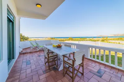 a patio with a table and chairs on a balcony at Villa Smaragdi - Private Sea View Villa in Falasarna