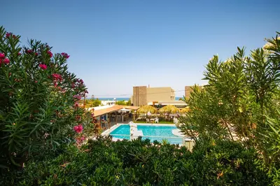 a view of a swimming pool through some trees at Andy's Gardens in Gerani Chanion